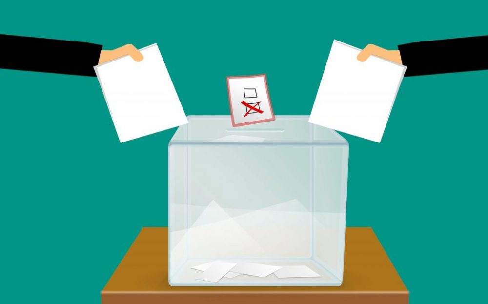 voto en blanco dibujo de dos manos con papeletas y una urna en medio